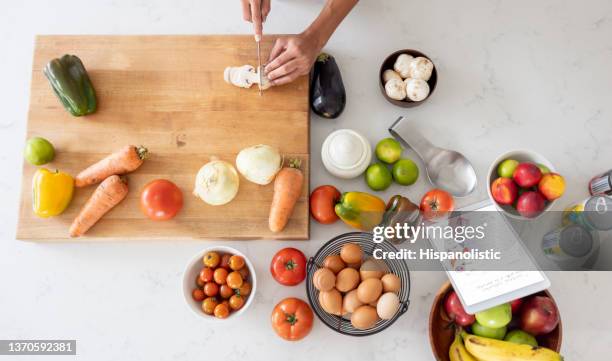 woman cooking at home following an online recipe - following recipe stock pictures, royalty-free photos & images