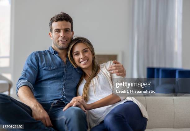 pareja amorosa relajándose en casa y sonriendo - newlywed fotografías e imágenes de stock