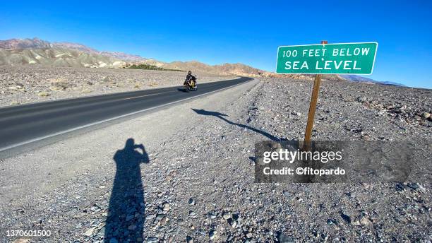 100 feet below sea level street sign in death valley national park - death valley stock-fotos und bilder