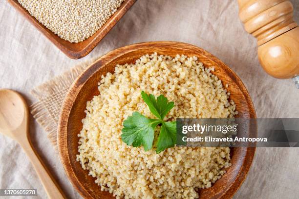 cooked quinoa in a wooden plate on the table, top view. - quinoa photos et images de collection