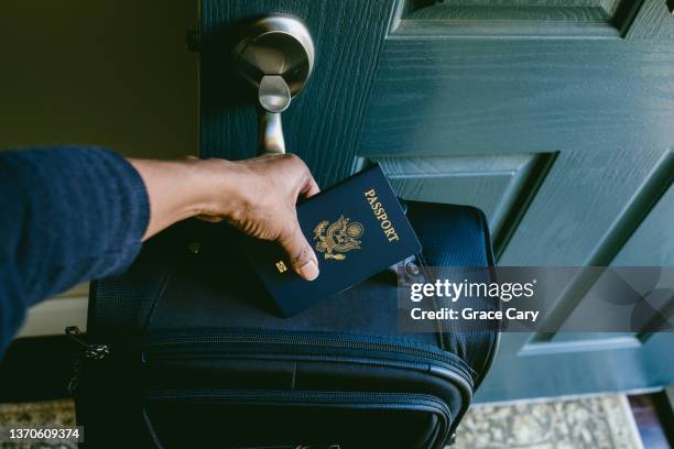 woman prepares to leave house with packed suitcase and passport - pasaporte fotografías e imágenes de stock