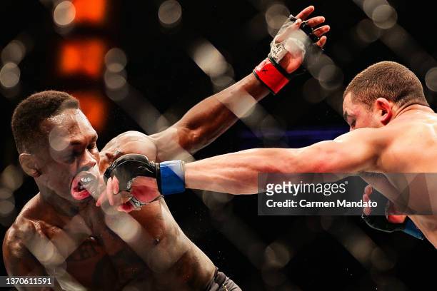 Israel Adesanya of Nigeria and Robert Whittaker of Australia exchange strikes in their middleweight championship fight during UFC 271 at Toyota...