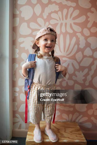 happy toddler posing in from of graphic wall getting ready for first day of school. - happy toddler stockfoto's en -beelden