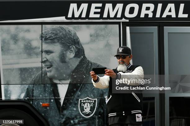 Raiders fan takes a photo with a bus decorated for a memorial service held for Hall of Fame NFL coach and broadcaster John Madden at RingCentral...