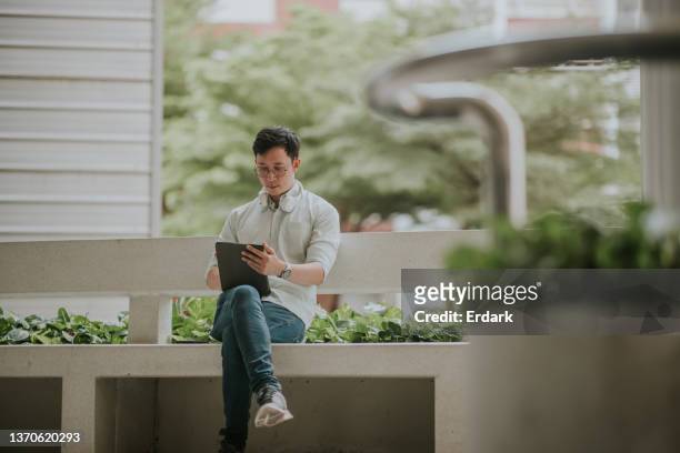 hombre de negocios usando tableta digital mientras él en la hora del almuerzo. - masters degree fotografías e imágenes de stock