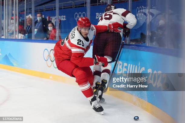 Oliver Lauridsen of Team Denmark pushes Oskars Batna of Team Latvia out of the way for the puck during the first period of the Men’s Ice Hockey...