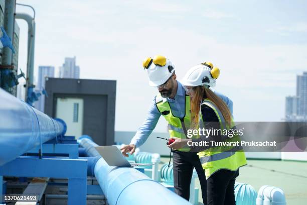engineer working on rooftop hotal a sunny spring day, outside in the city. - suministro de energía fotografías e imágenes de stock