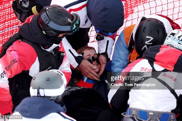 Coach from Team France consoles Camille Cerutti of Team France as medical staff attend to her after she crashed during the Women's Downhill on day 11...