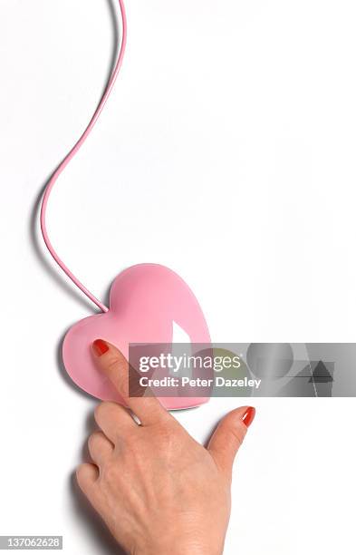 female hand on heart shaped mouse with copy space - dating online stock pictures, royalty-free photos & images