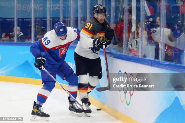 Samuel Takac of Team Slovakia plays the body on Moritz Muller of Team Germany at the end boards in the third periodduring the Men’s Ice Hockey...