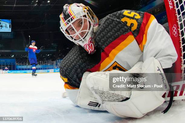 Martin Gernat of Team Slovakia l as goaltender Mathias Niederberger of Team Germany looks on after failing to stop the puck from crossing the goal...