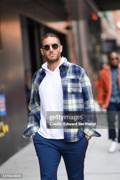 Guest wears black sunglasses, a white hoodie sweater, a ,navy blue and white checkered print pattern shirt, navy blue suit pants, outside Jason Wu ,...