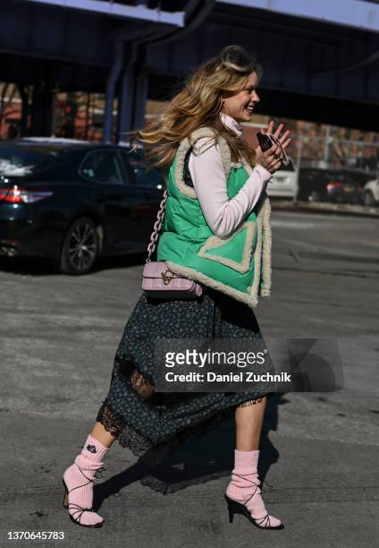 Guest is seen wearing a Coach jacket and Coach dress outside the Coach show during New York Fashion Week A/W 2022 on February 14, 2022 in New York...