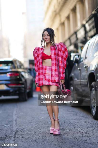 Jessica Wang wears a gold large pearls earrings, a red V-neck bra underwear, a red and pink checkered sequined pattern puffy shoulder / oversized...