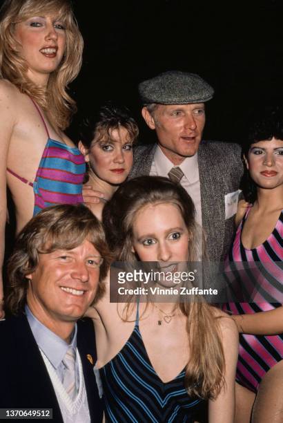 Canadian-American actor Dean Butler, wearing a dark blue jacket over a pale blue short and sweater, and American singer and songwriter Mike Love...