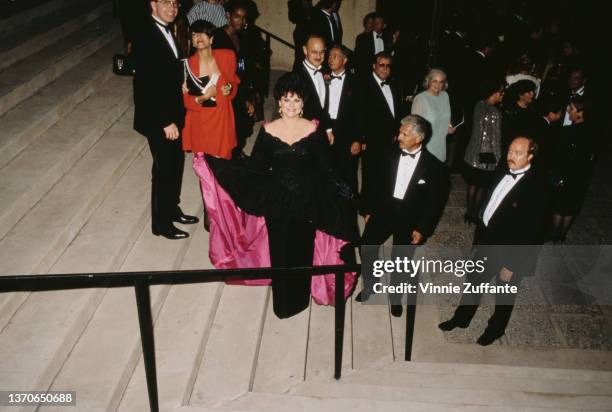 American actress Delta Burke, wearing a pink-and-black evening gown, on a flight of steps with people at the 42nd Annual Primetime Emmy Awards, held...