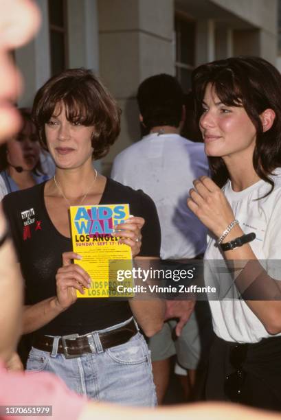 American actress Teri Hatcher, holding an AIDS Walk Los Angeles flyer, and American actress Sandra Bullock, wearing a white t-shirt with a nametag,...