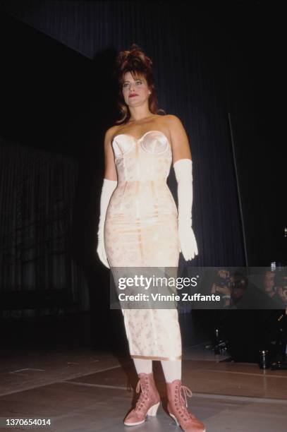 American actress Lorraine Bracco, wearing a white dress with white evening gloves, on the catwalk during the Jean Paul Gaultier Fashion Show, for the...