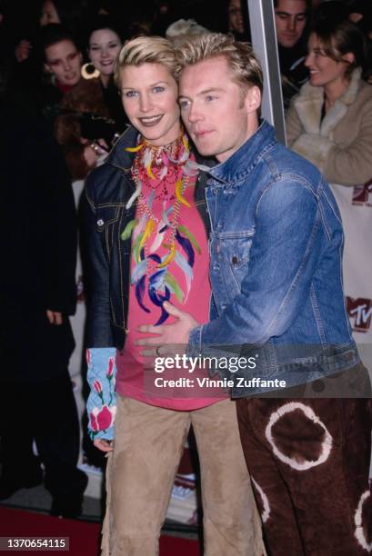 Irish model Yvonne Keating and her husband, Irish singer and songwriter Ronan Keating, wearing a white t-shirt beneath a denim jacket, attends the...