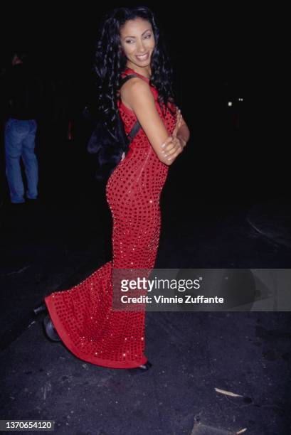 British actress and television personality Downtown Julie Brown, wearing a red evening gown and a black rucksack, attends a Details magazine party in...