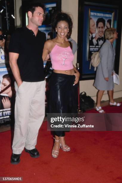 British actress and television personality Downtown Julie Brown and a man attend the Westwood premiere of 'Mickey Blue Eyes, ' held at the Mann Bruin...