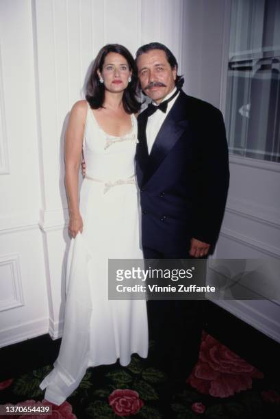 American actress Lorraine Bracco, wearing a white dress with a scooped neckline, and he husband, Mexican-American actor Edward James Olmos attend the...