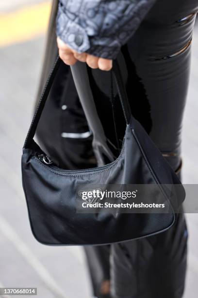 Influencer Jackie Hide holding a black bag by Prada during a street style shooting on February 14, 2022 in Palma de Mallorca, Spain.