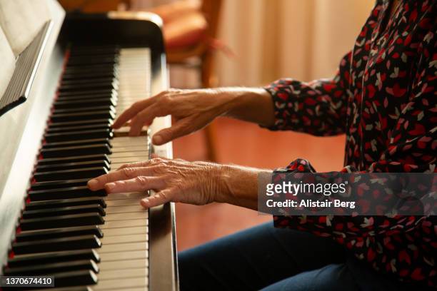 close up of senior woman's hands playing piano - practicing piano stock pictures, royalty-free photos & images