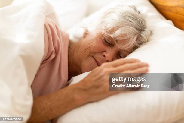 senior woman sleeping in the morning - positive healthy middle age woman stock pictures, royalty-free photos & images