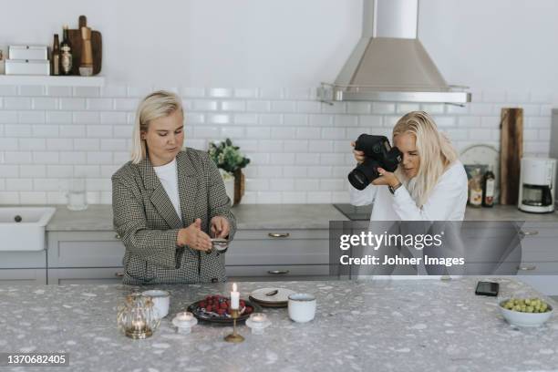 women photographing food in kitchen - food design stock pictures, royalty-free photos & images