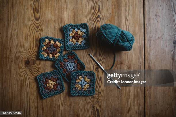 crochet squares on wooden background - knit stockfoto's en -beelden