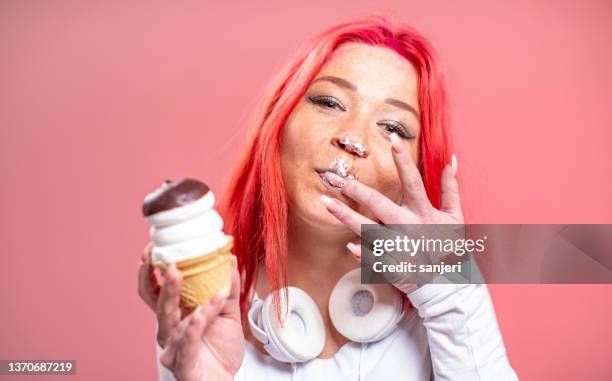 お菓子を食べる女の子の肖像 - 指をくわえる ストックフォトと画像