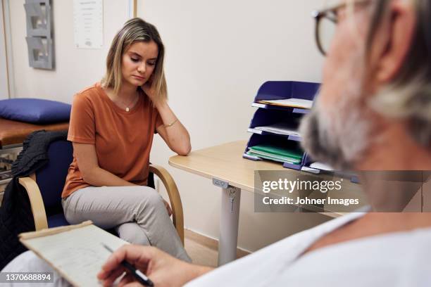 doctor and patient in doctor's office - sad doctor stock pictures, royalty-free photos & images