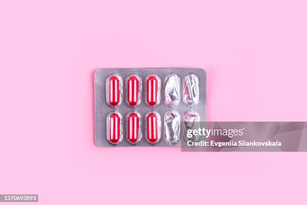 blister pack with red pills on pink background. - pill container stock pictures, royalty-free photos & images