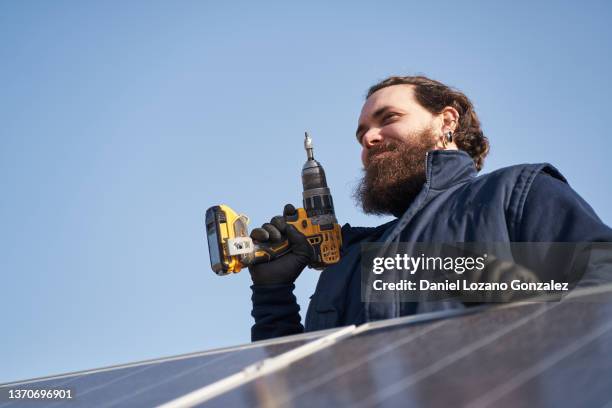 man using screwdriver during solar panels installation - schraubenzieher stock-fotos und bilder