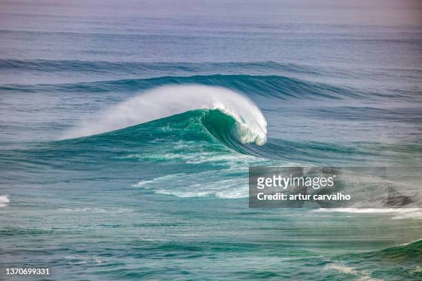 nazaré big waves in the landscape of portugal atlantic coast - nazare big wave surfing stock pictures, royalty-free photos & images