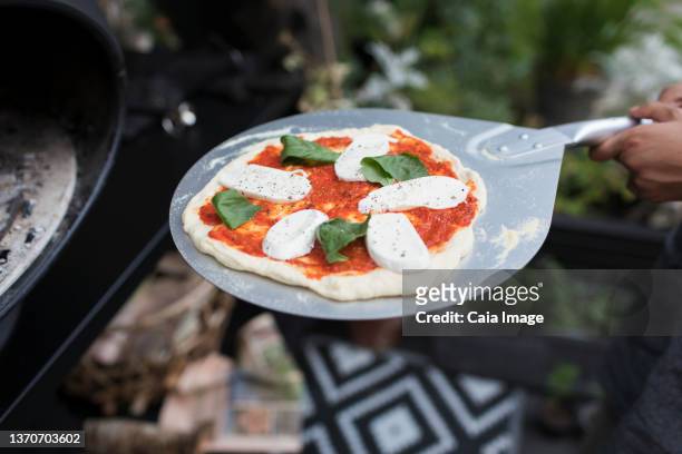 fresh homemade pizza on pizza peel at oven - making pizza stock pictures, royalty-free photos & images