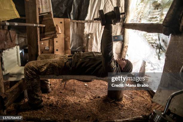 Sargent Sergij lifts weights at a makeshift gym at his unit's position at the contact line near the Village of Svitlodarsk, Donetsk region on...