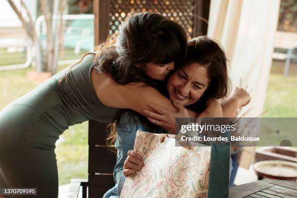 girl giving birthday gift to mother - child giving gift stock-fotos und bilder