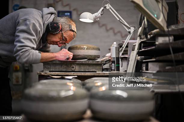 John Brown works on a piece of granite rock being made into a curling stone at Kays Curling on February 15, 2022 in Mauchline, Scotland. Kays Curling...