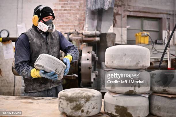 John Scott lifts an unfinished curling stone on February 15, 2022 in Mauchline, Scotland. Kays Curling manufacture and export curling stones to top...