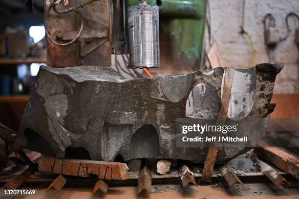 John McCormack works on a piece of granite rock being made into a curling stones at Kays Curling on February 15, 2022 in Mauchline, Scotland. Kays...