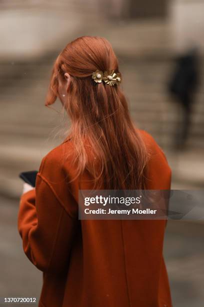 Guest is seen wearing an orange coat and tan faux leather bag outside the Ulla Johnson show during New York Fashion Week A/W 2022 on February 13,...