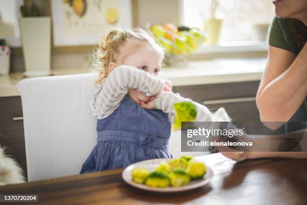 mother and baby girl blonde in home interior , eat broccoli - hate broccoli stock pictures, royalty-free photos & images