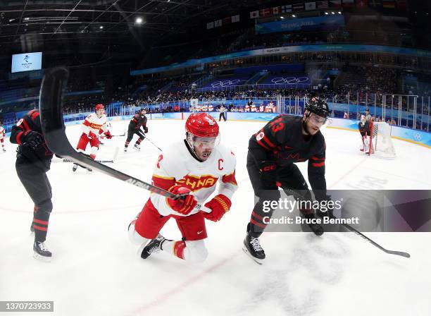 Tyler Wotherspoon of Team Canada is challenged by Jinguang Ye of Team China in the third period during the Men’s Ice Hockey Qualification Playoff...