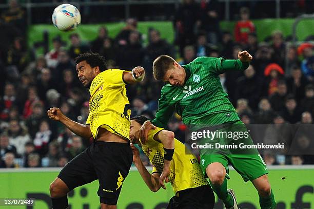 Patrick Owomoyela of Dortmund and Sebastian Proedl of Bremen jump for a header during the Stadtwerke Duesseldorf Wintercup 2012 third place match...