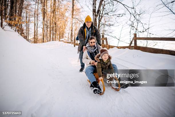 sleighing time - family in snow mountain stockfoto's en -beelden