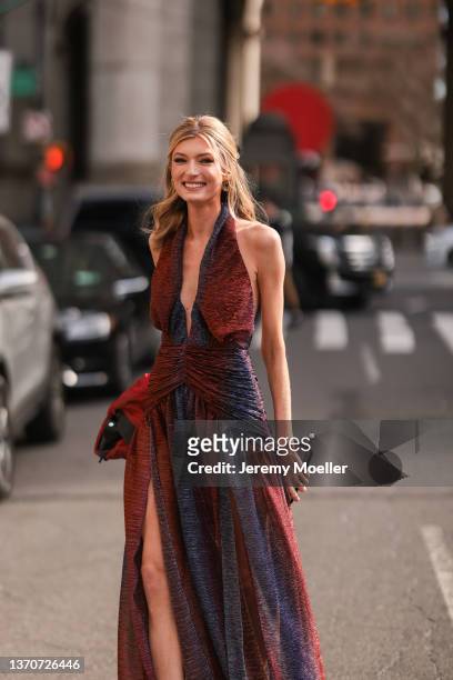 Sophie Sumner wearing a black leather jacket and a red maxi dress outside PatBo during New York City Fashion Week on February 12, 2022 in New York...