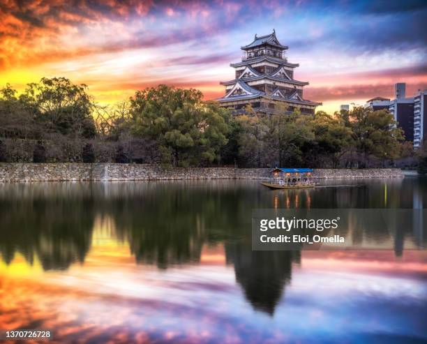 exterior of hiroshima castle with tourists boat in the morning. japan - hiroshima stock pictures, royalty-free photos & images