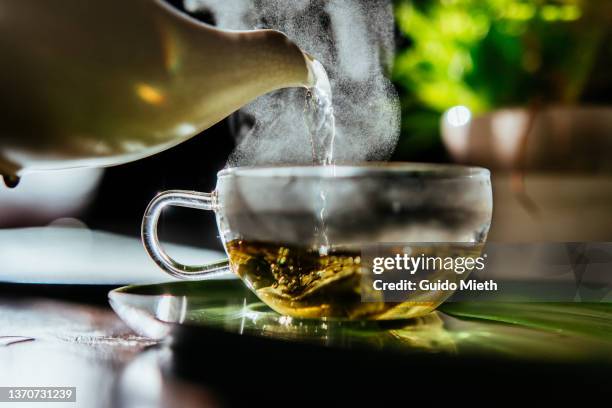fresh hot water for organic sage herbal tea at teatime. - kräutertee stock-fotos und bilder